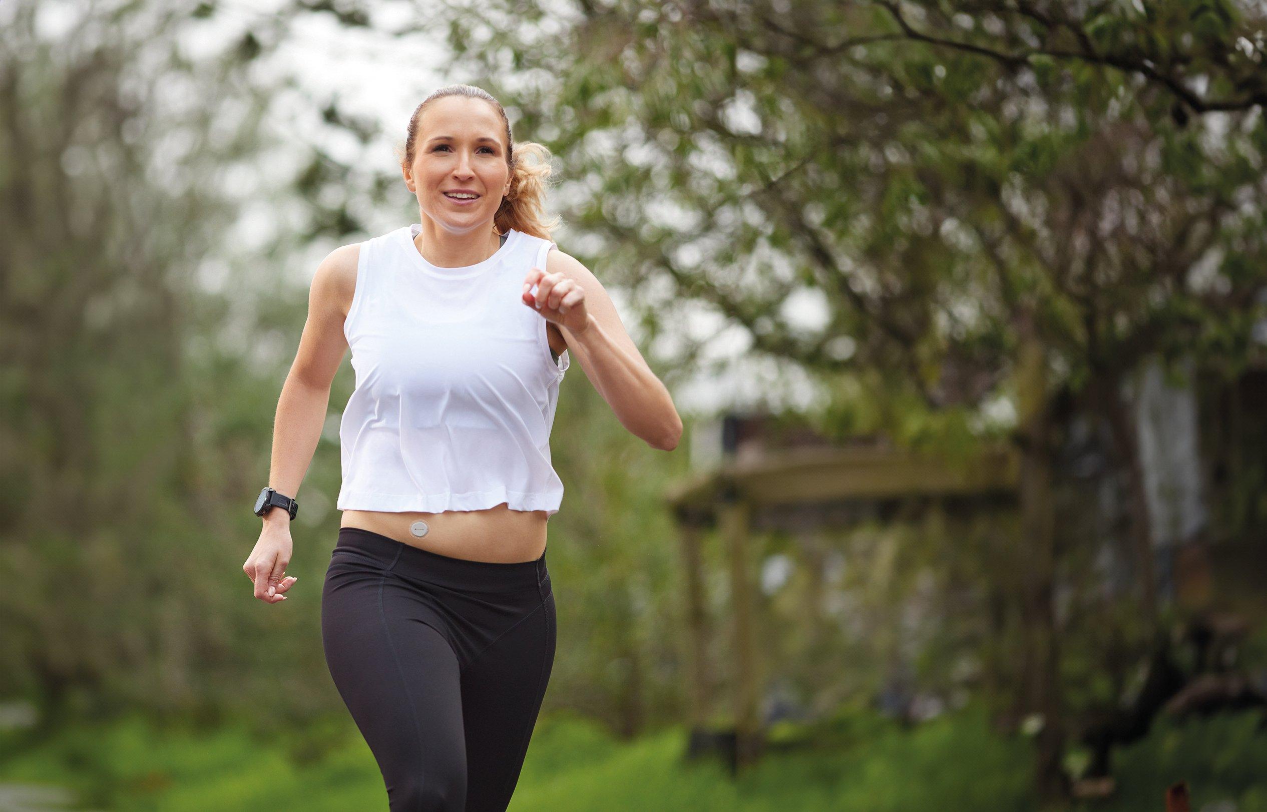Femme au bord d'une piscine avec un capteur Dexcom ONE+ sur le bras